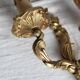 Vintage wall sconce in gold metal with two arms in classic style.