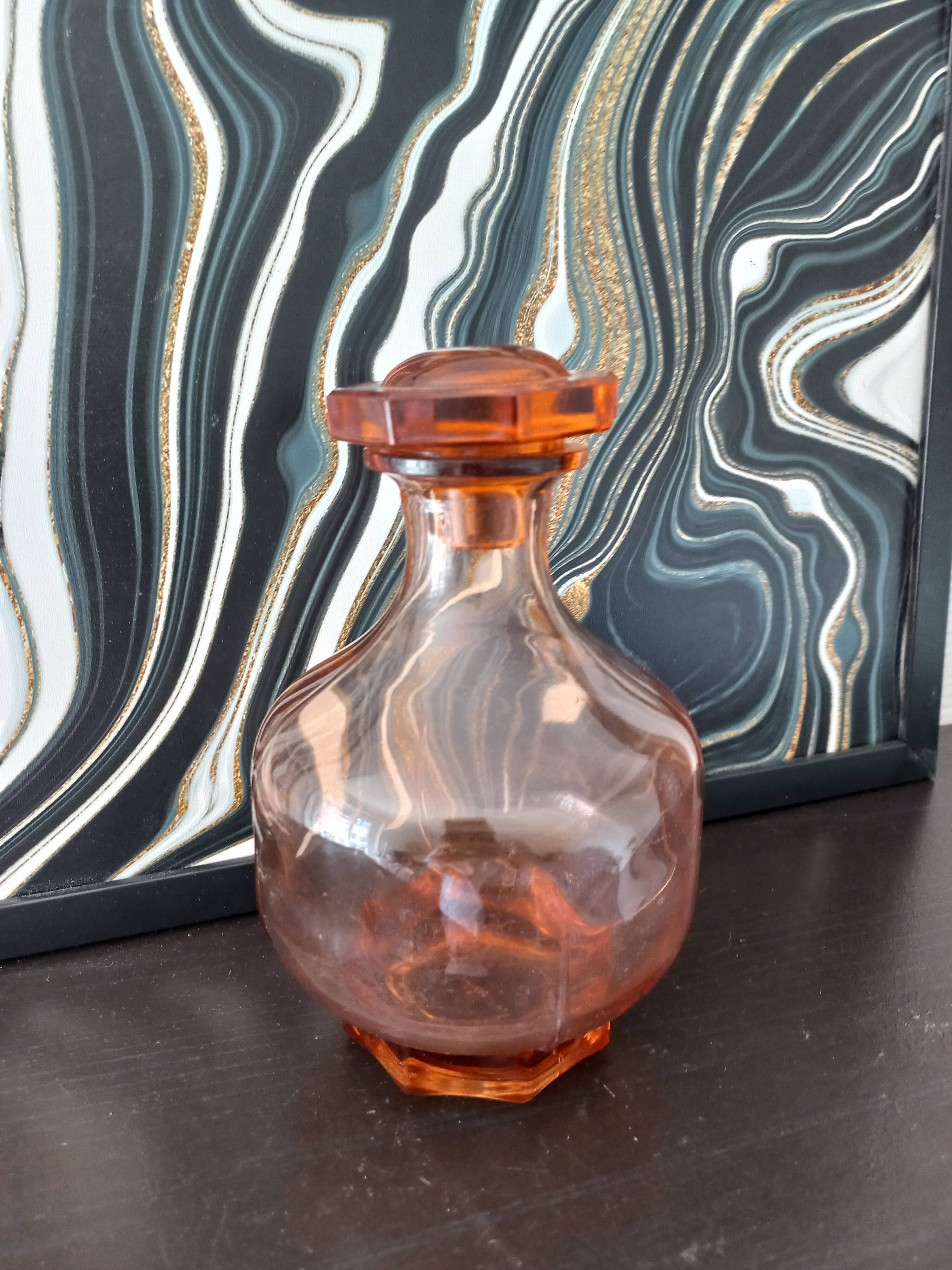 Vintage glass carafe in pink-orange, retro-chic style.