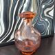 Vintage glass carafe in pink-orange, retro-chic style.