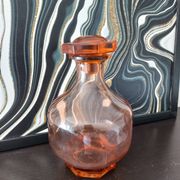 Vintage glass carafe in pink-orange, retro-chic style.