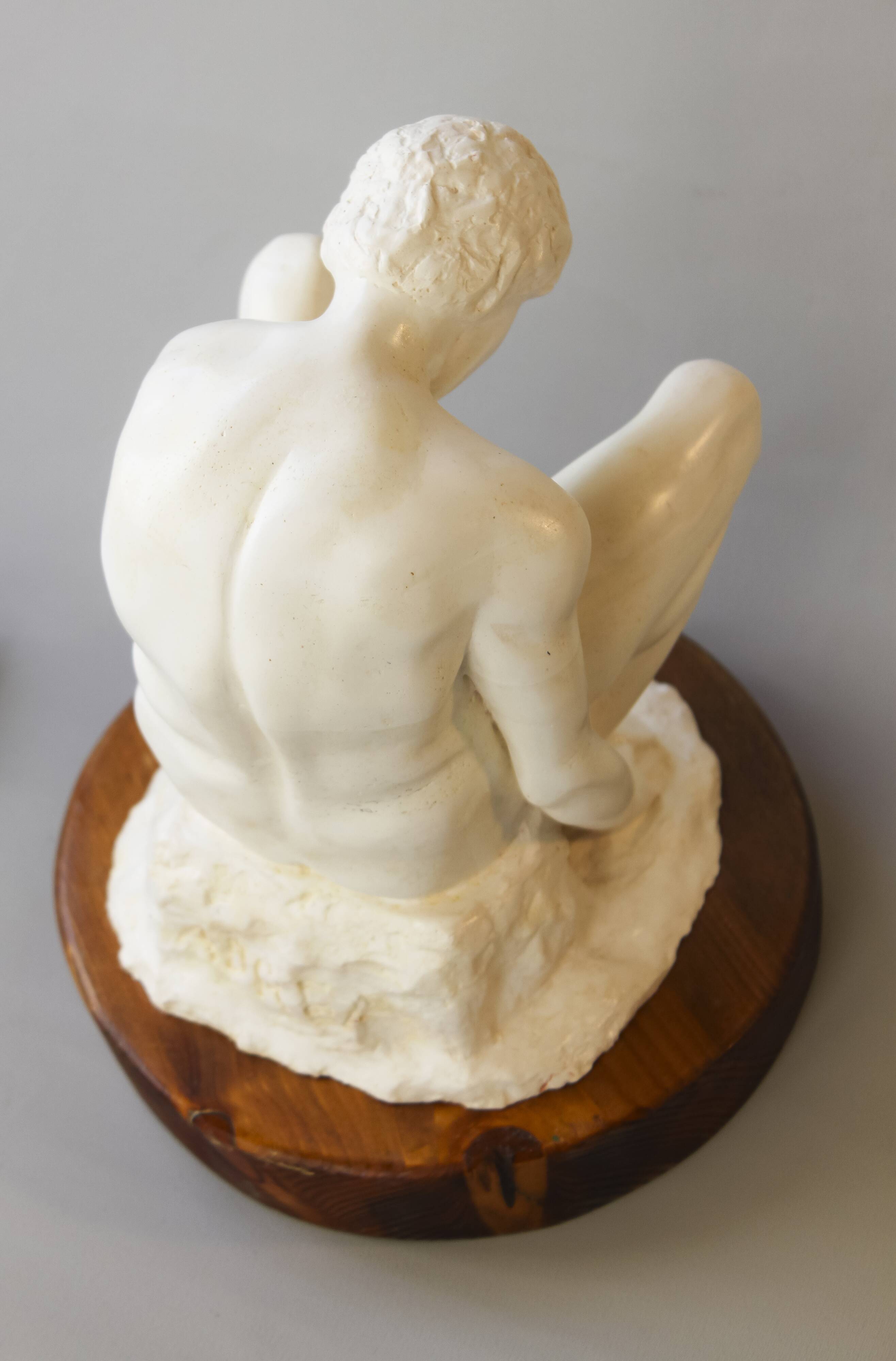 Sculpture of a seated man. Classical male sculpture. Male figure.