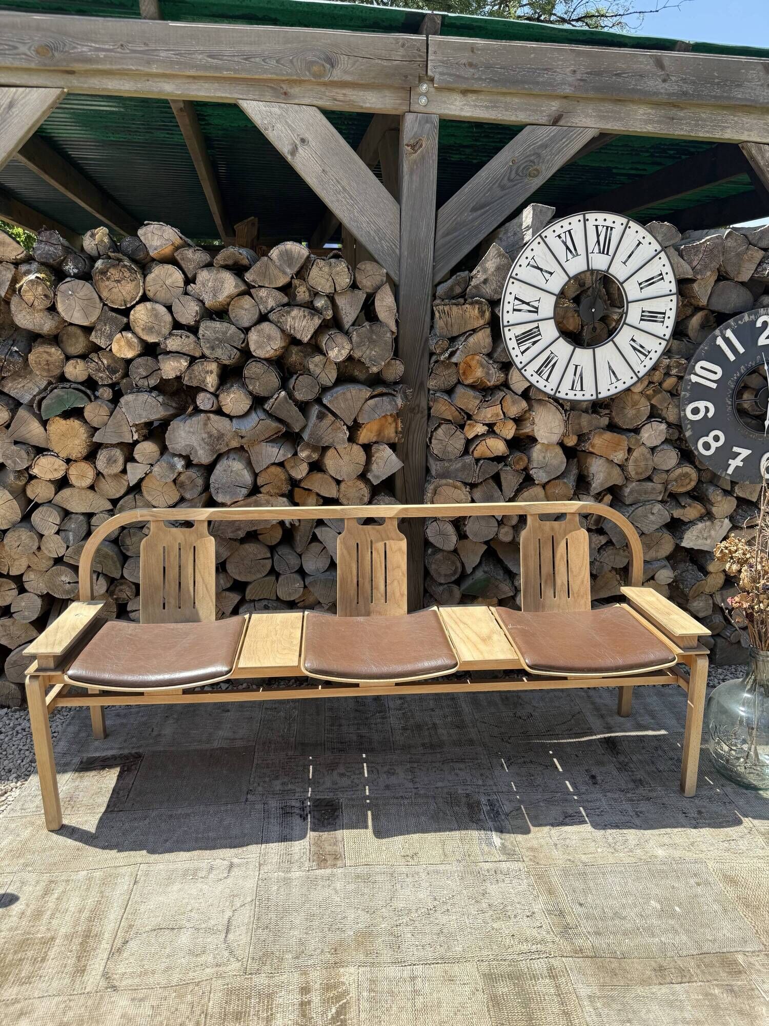 Baumann bench with wooden frame and faux leather seat.