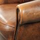 Fauteuil club en cuir de peau de mouton avec un coussin de siège fixe.