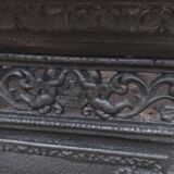 Black cast iron wood burning stove with solid brass handle.