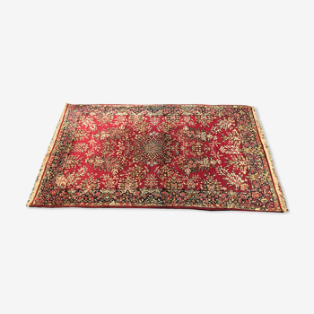 Tapis d’orient en laine à décor de fleurs sur fond rouge