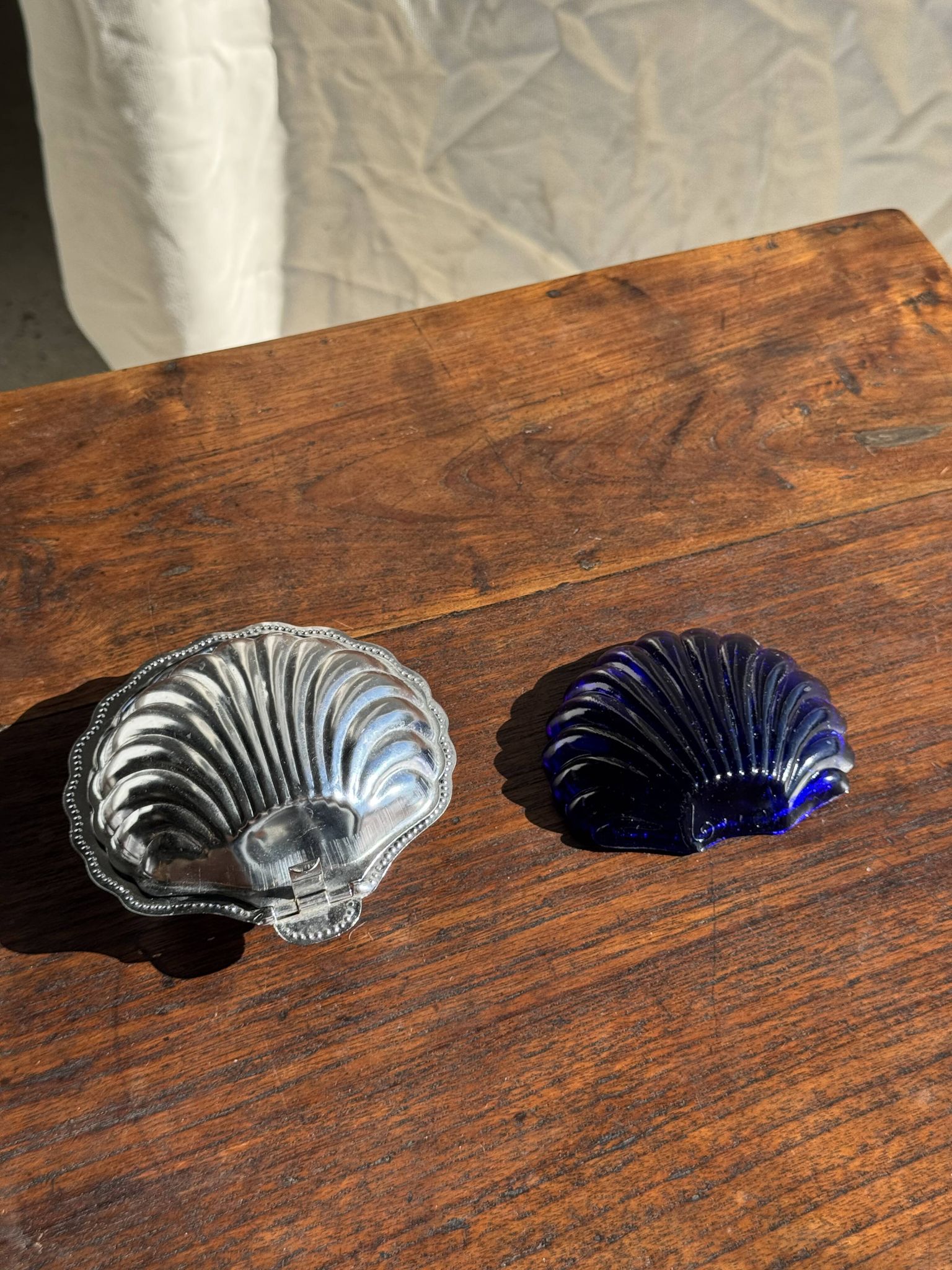Vintage silver-plated shell butter dish with blue bowl.