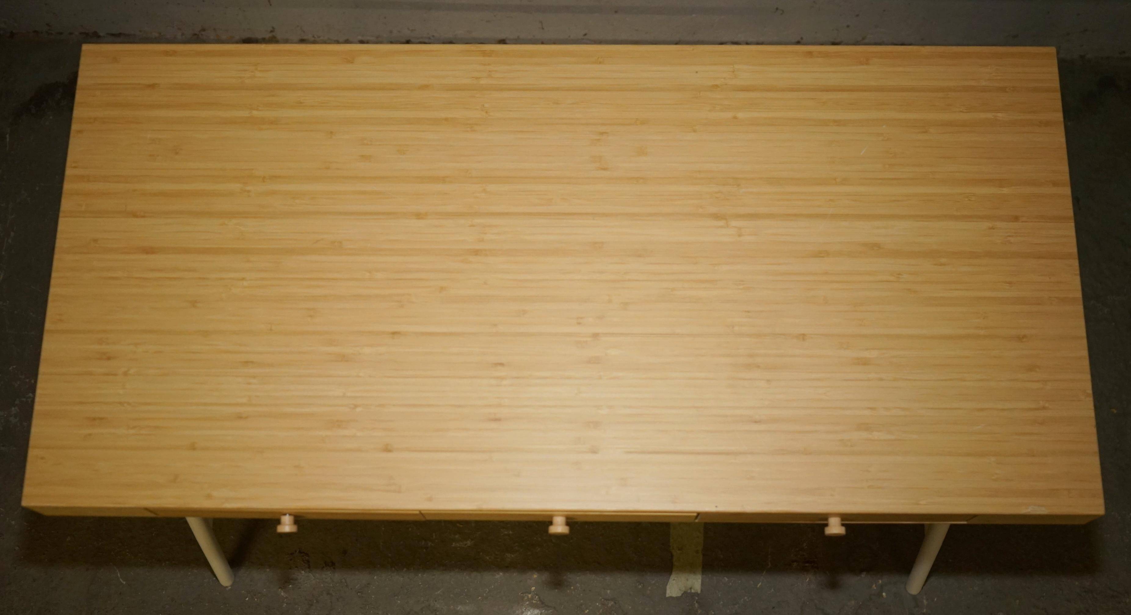 Small bamboo desk with three drawers.