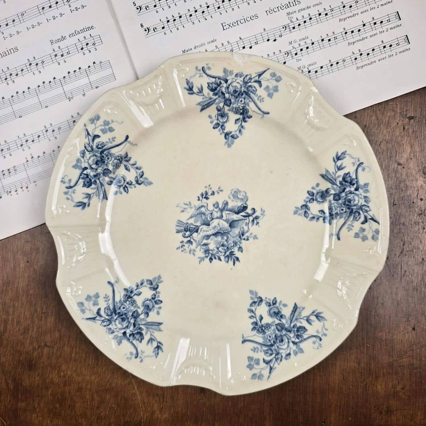 Old Gien plate with carved edges featuring doves and blue flowers, circa 1920-1930.