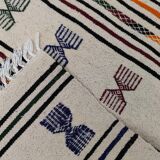 White carpet with multicolored Berber patterns woven hands