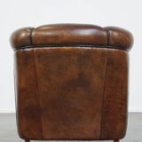 Fauteuil club en cuir de mouton foncé avec passepoil noir