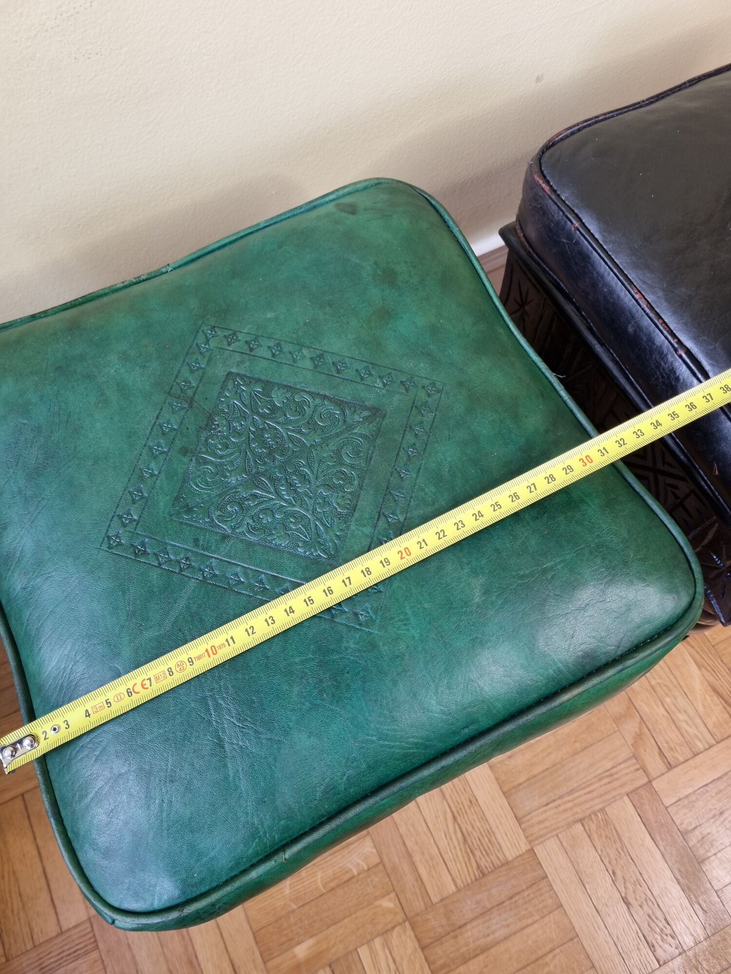 Pair of Moroccan poufs in stamped leather with a carved wooden base, Rabat