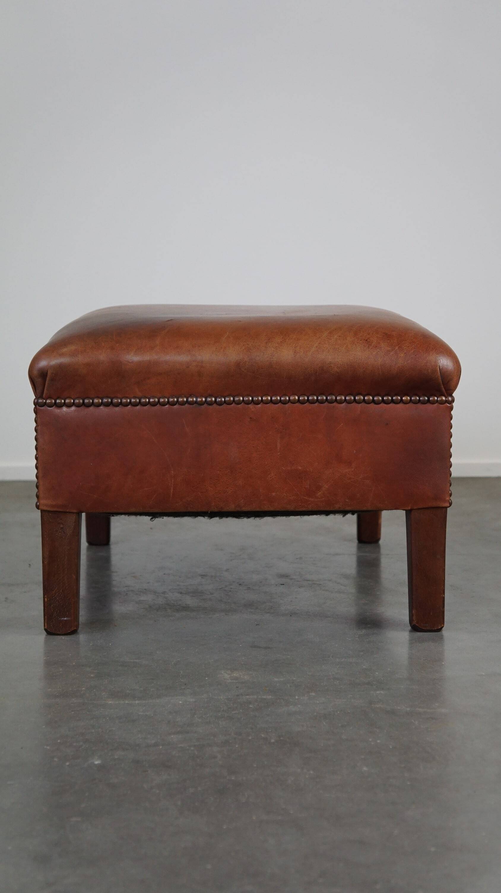 Leather ottoman in classic English style finished with decorative nails