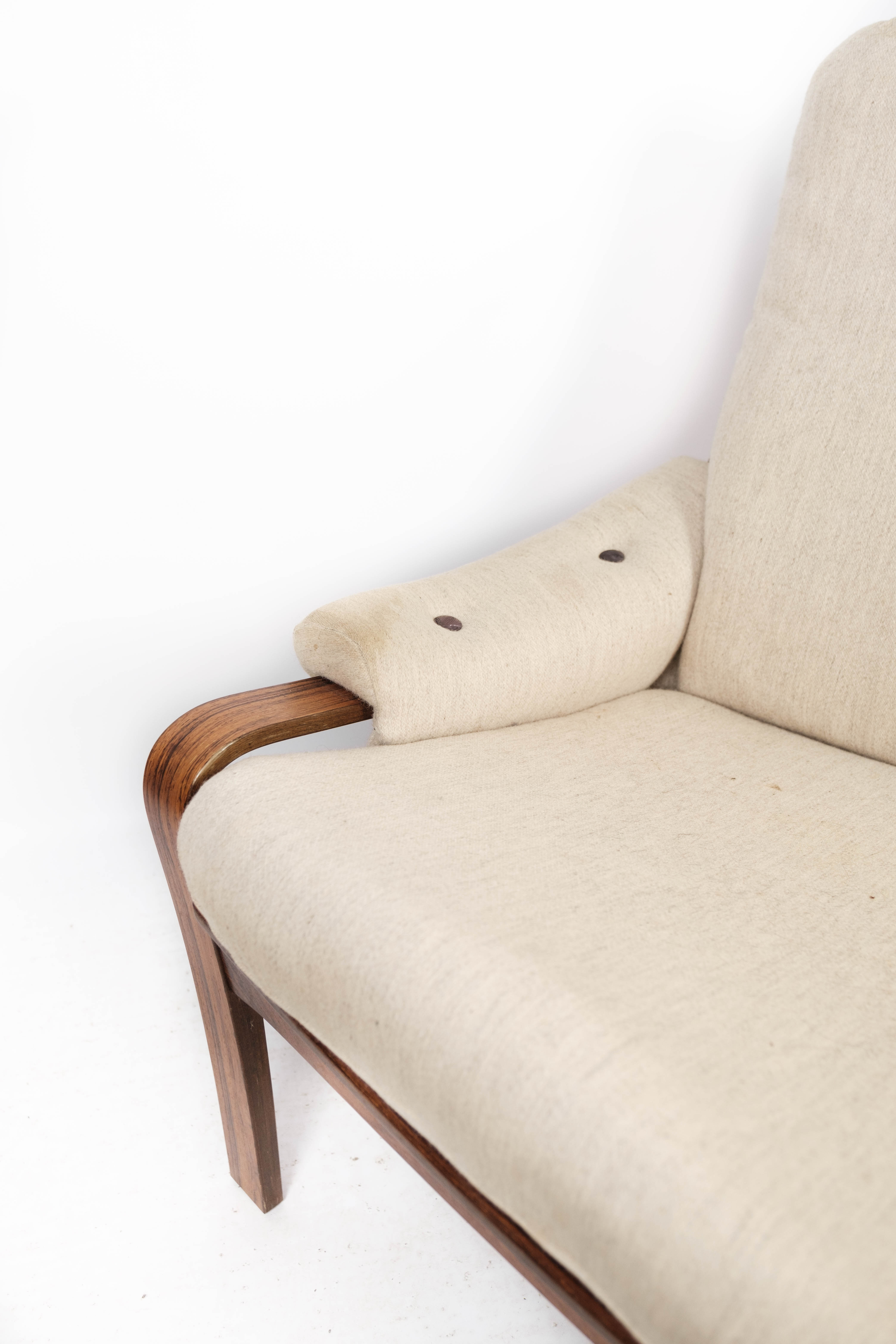 Armchair in rosewood and upholstered with light fabric, of Danish design, 1960s
