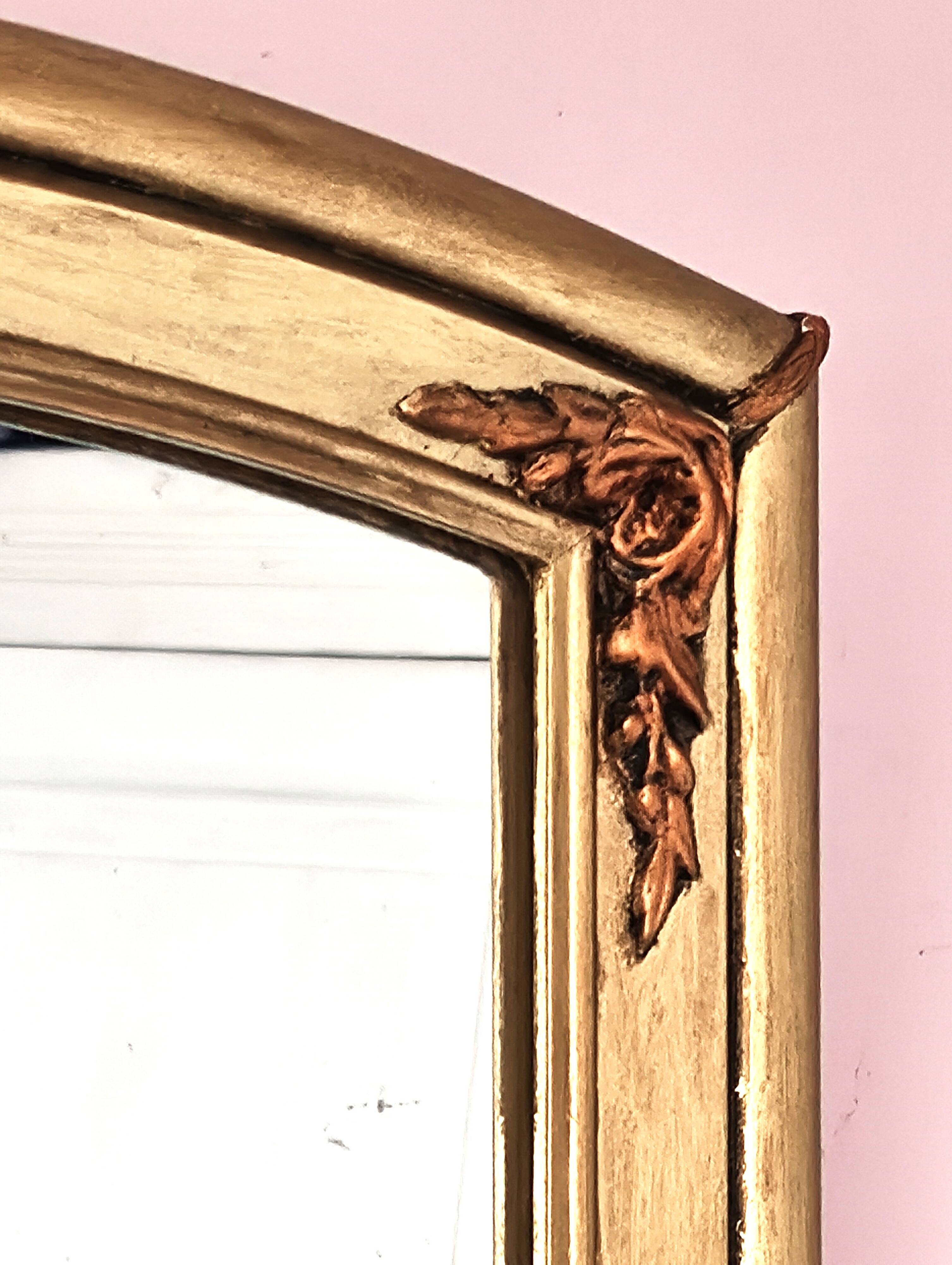 Art Deco mirror in gilded wood with curved floral decorations.