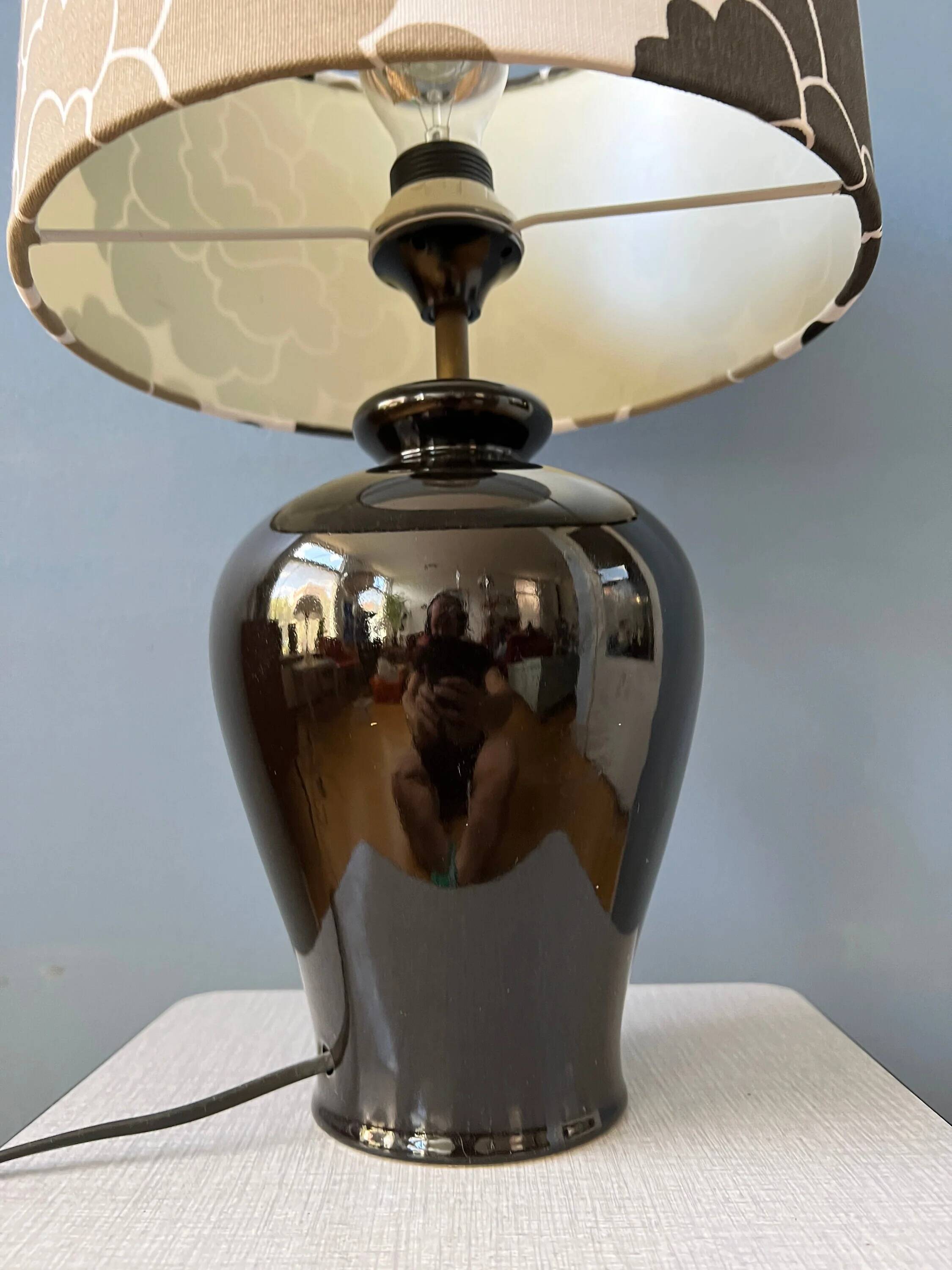 Small Space Age table lamp with a porcelain base and black and white flower shade.