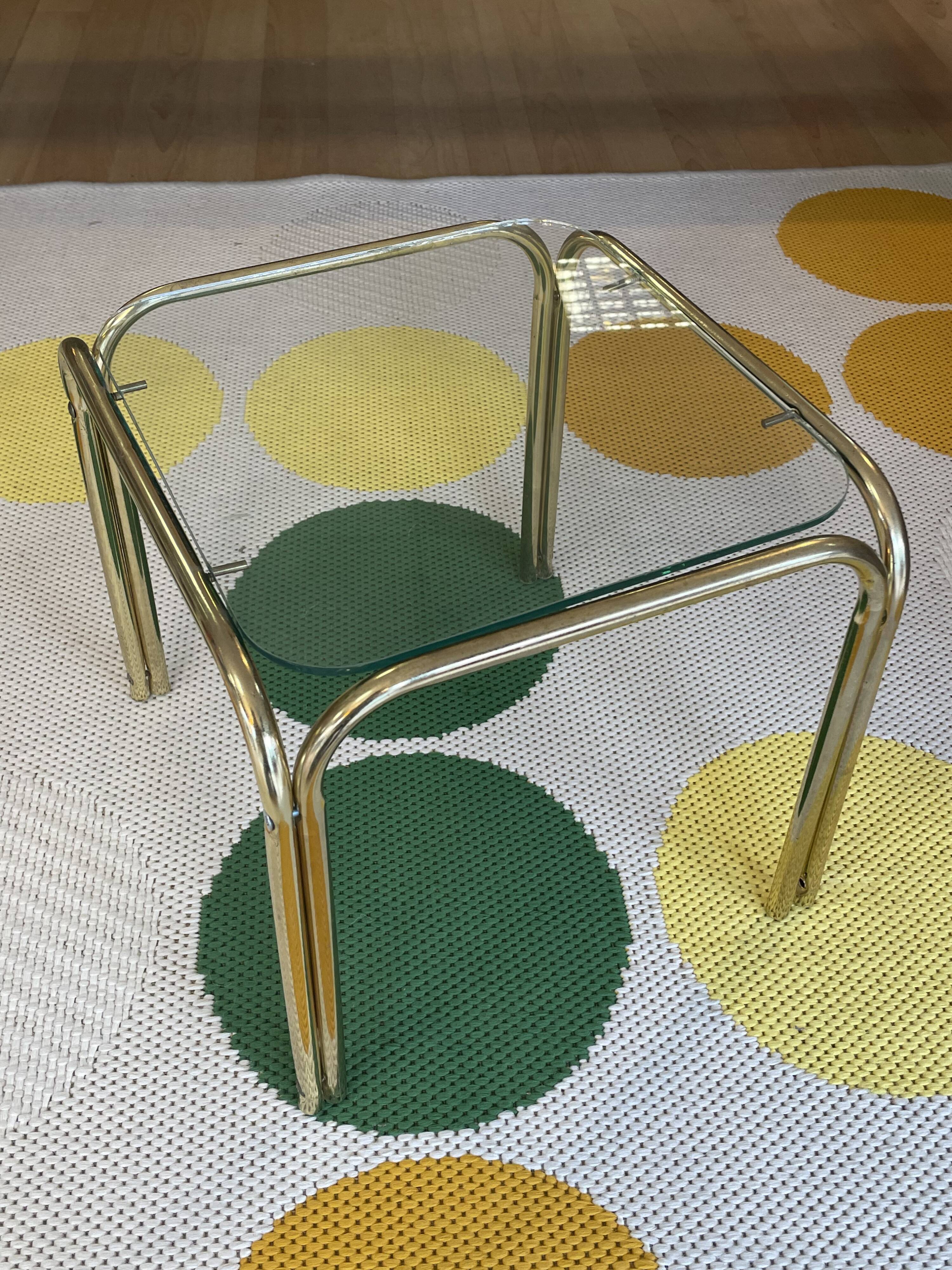 Pair of small nesting coffee tables in gold tubular metal & transparent glass tops