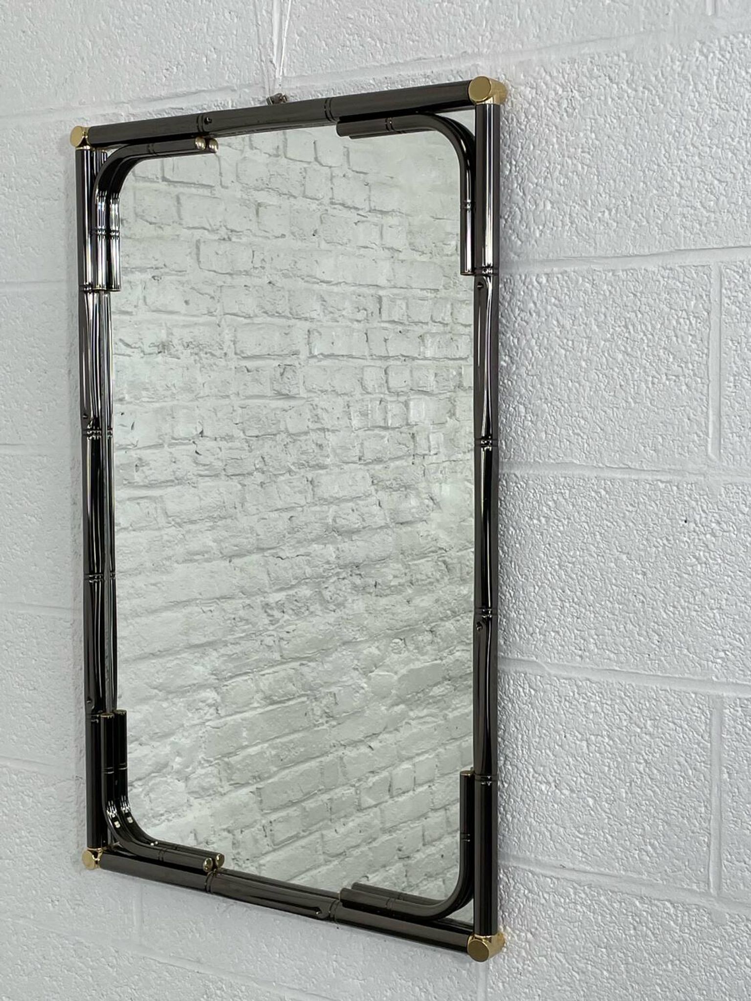 Mirror in black metal and brass with gunmetal finish