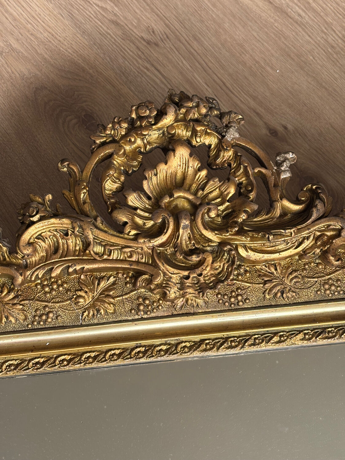 Golden mirror with a pediment from the early 20th century.