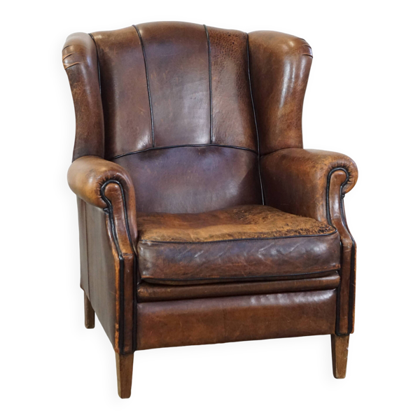 Fauteuil à oreilles en cuir de mouton patiné