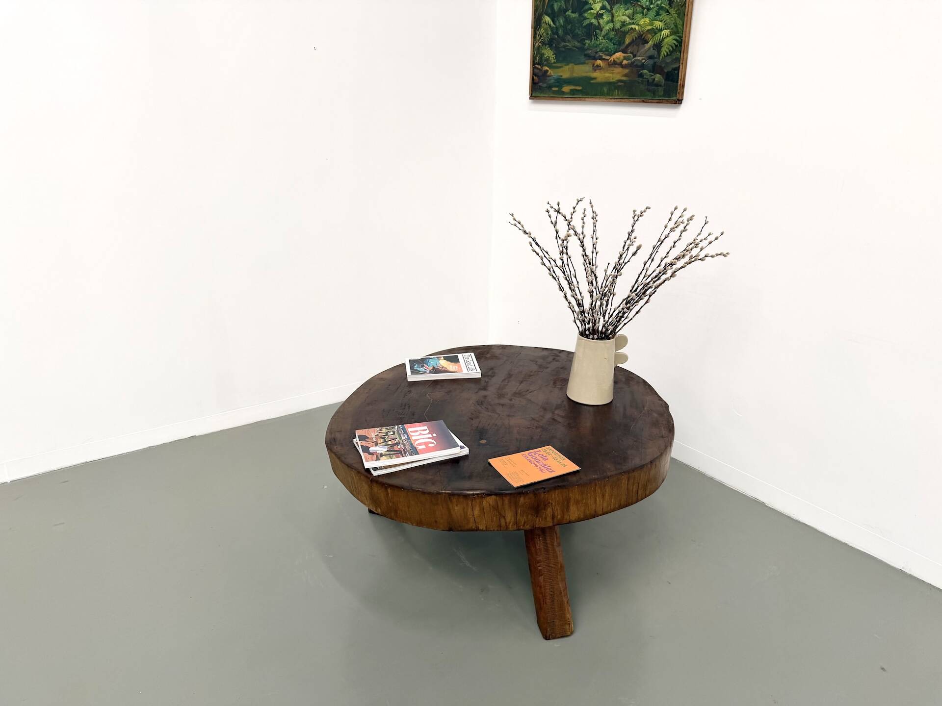 Brutalist coffee table in solid teak, monolithic slab, tripod base.