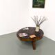 Brutalist coffee table in solid teak, monolithic slab, tripod base.