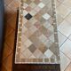 Beige ceramic coffee table with black metal legs.