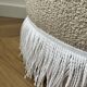 Pouf rond avec franges en bas, en bouclée crème.