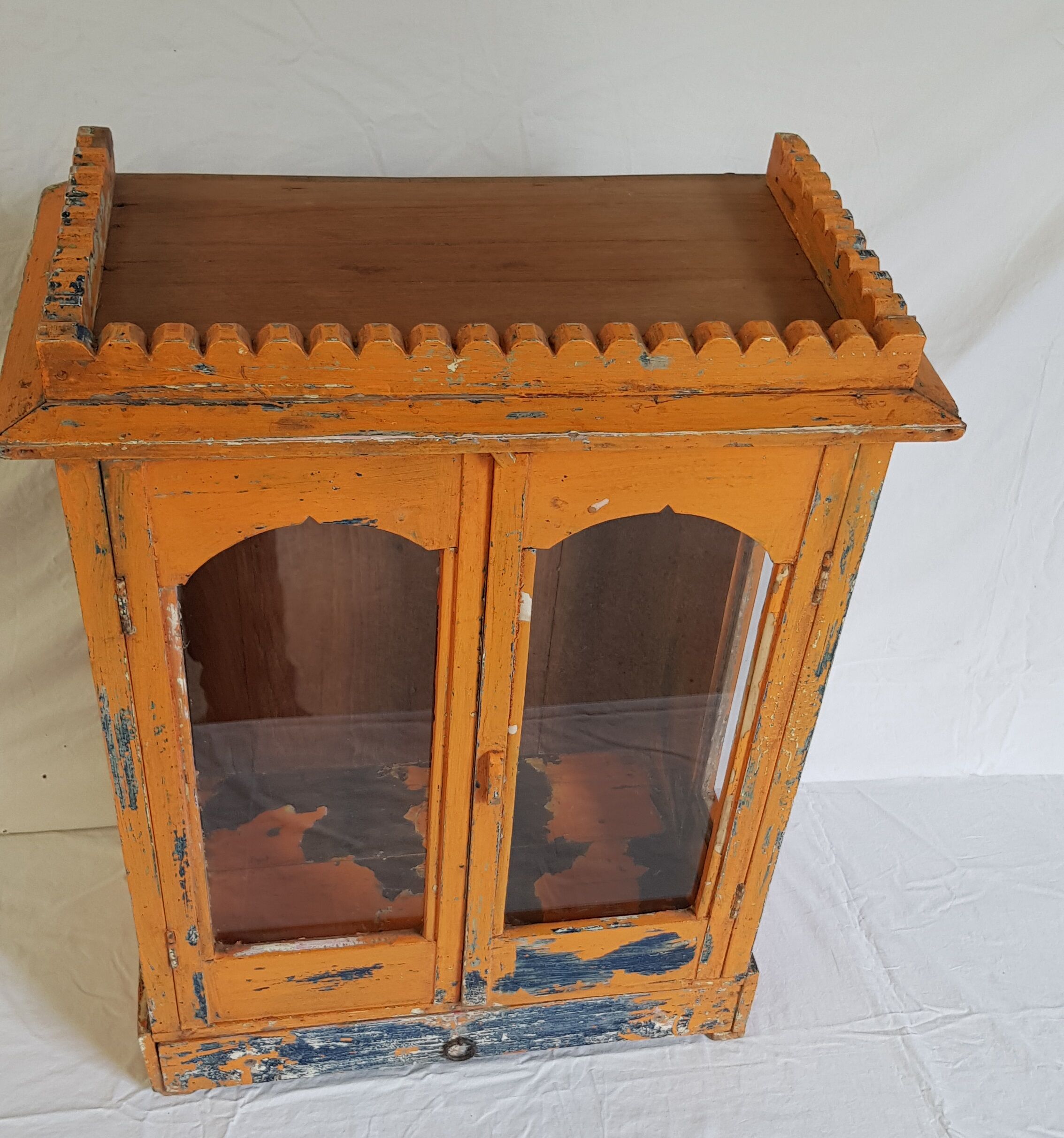 Old temple-showcase with teak offerings