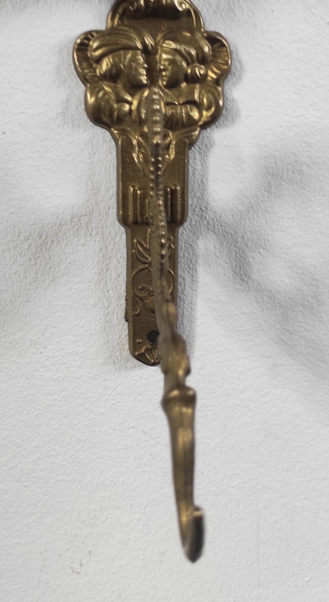 Vintage brass coat hook with marine creature motif and medallion.