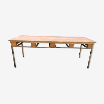 Table vintage moderniste à piétement tubulaire métallique et plateau recouvert d’une toile cirée.