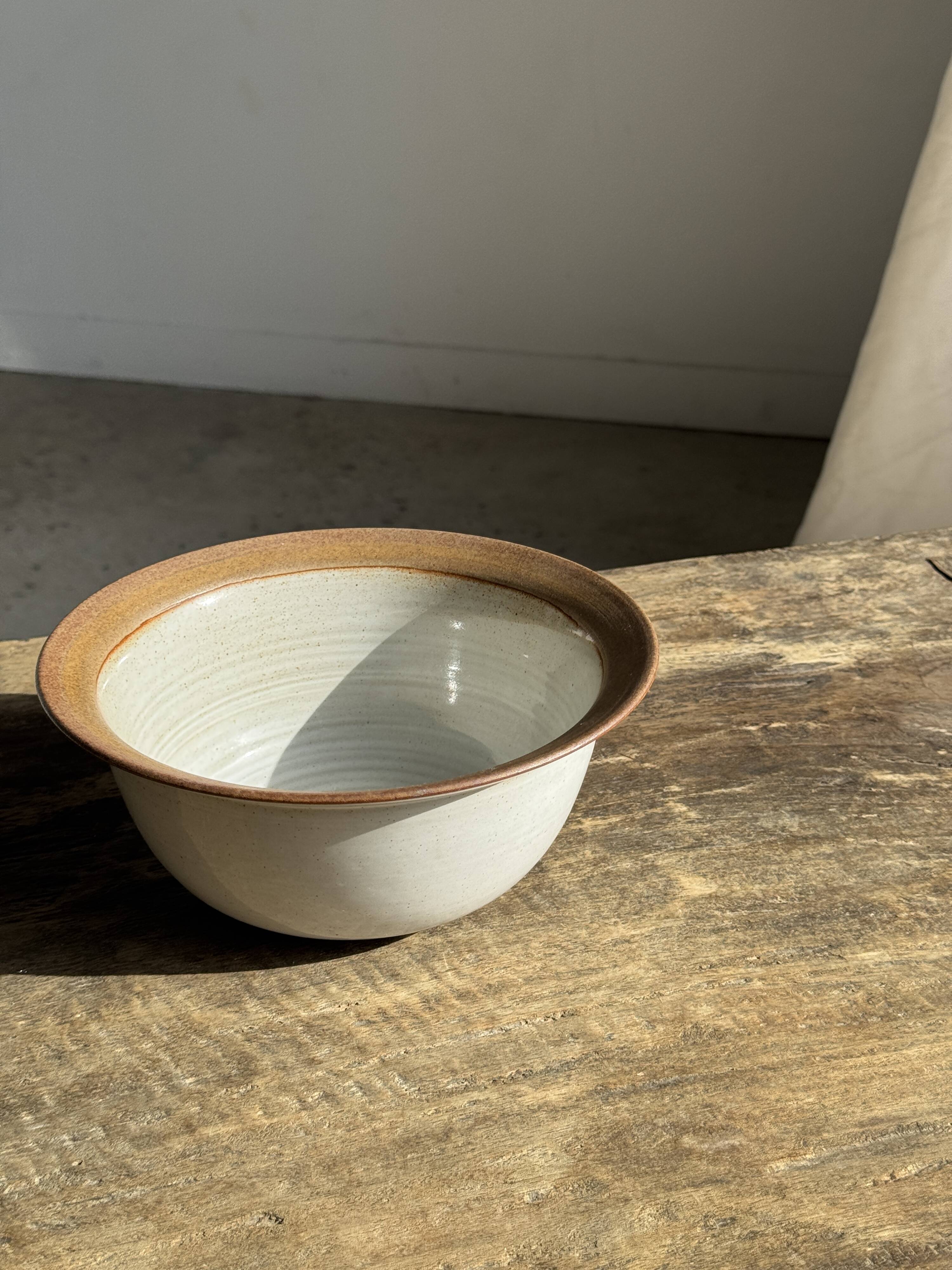 Small thick stoneware bowl with a stylised flower pattern in white on the outside, b
