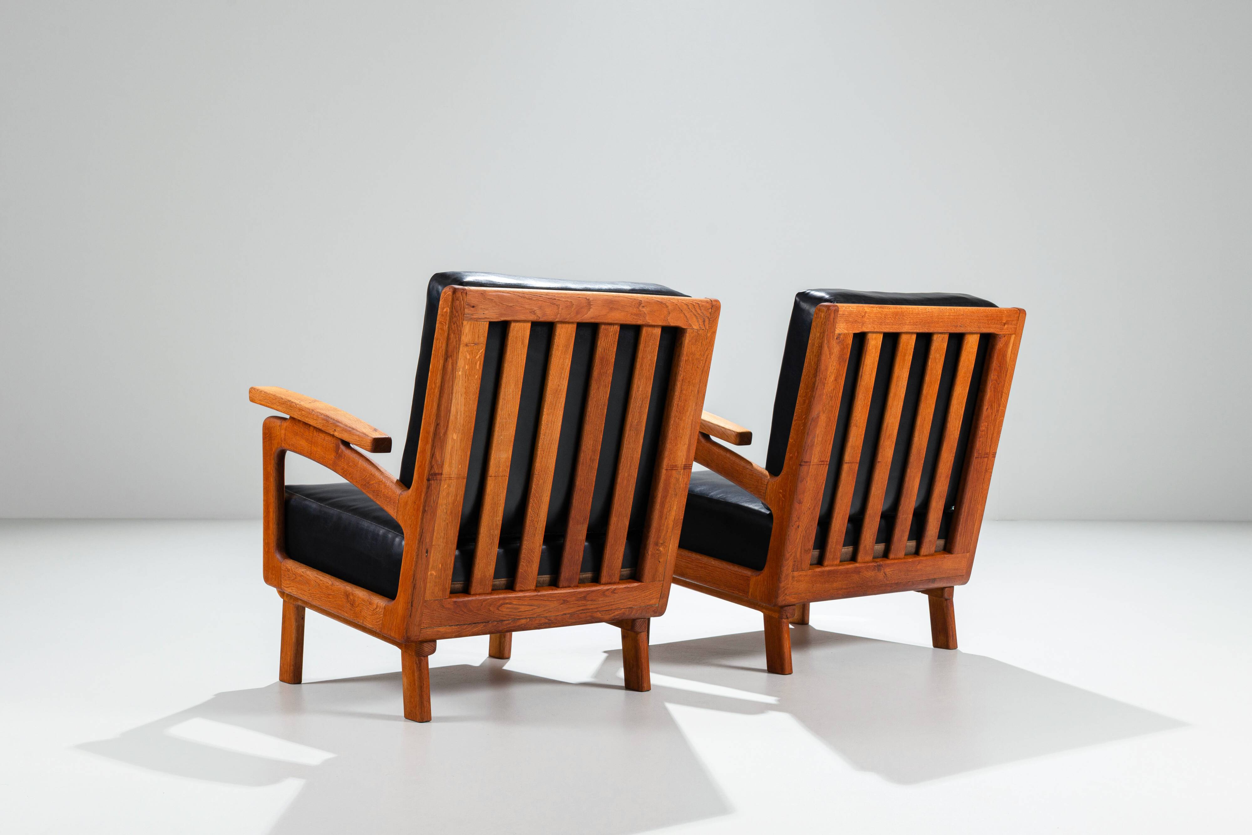 Pair of Belgian lounge chairs in solid oak with leather cushions