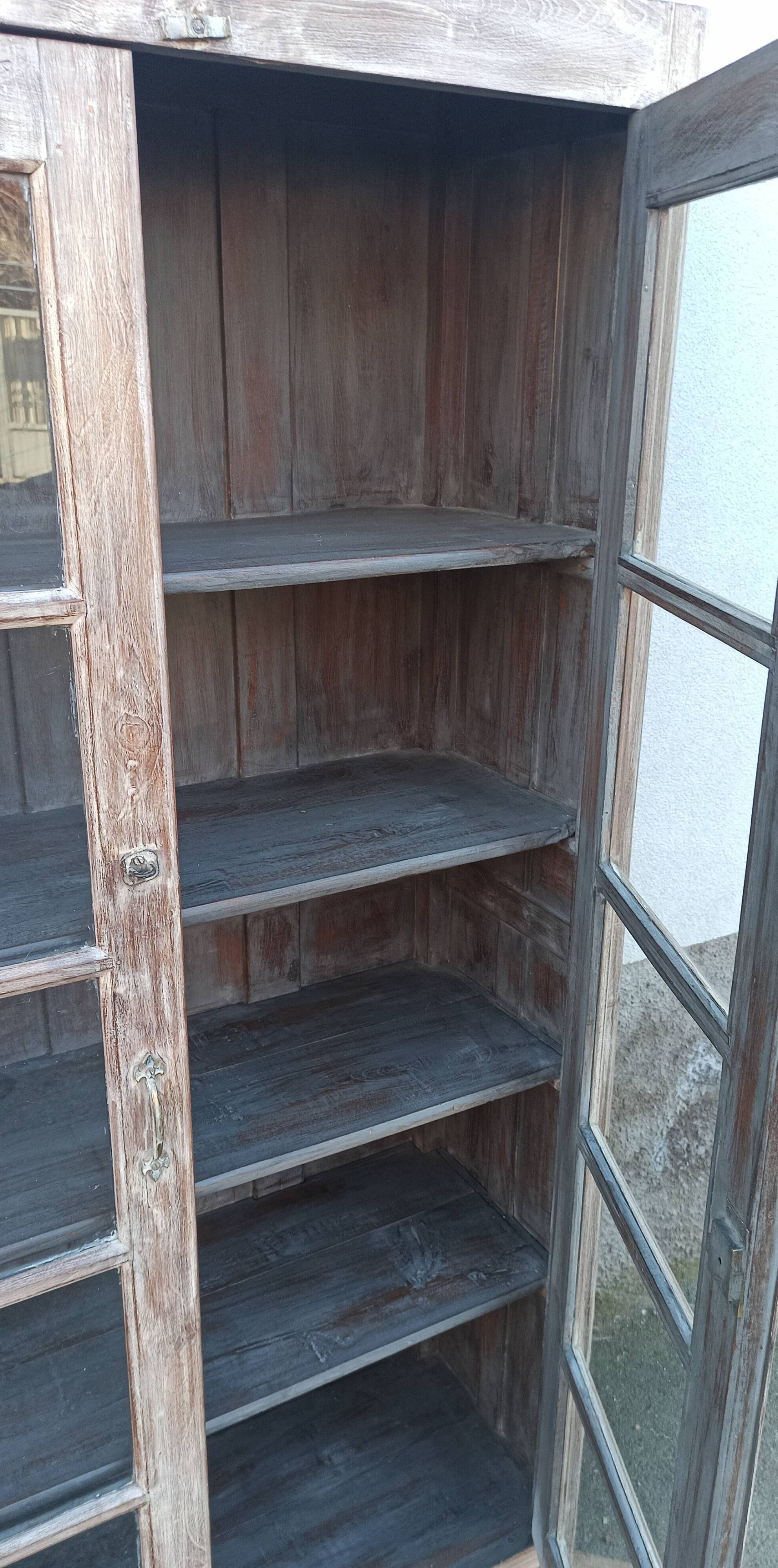 Glass cabinet in old whitewashed wood
