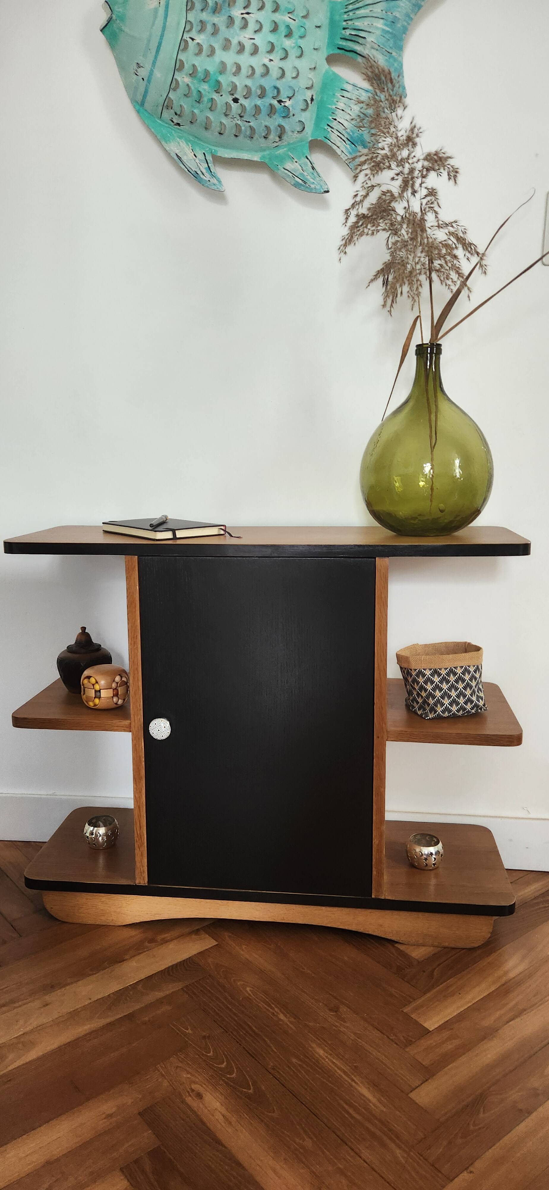 Compact bar cabinet with a pivoting door in black wood.