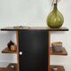 Compact bar cabinet with a pivoting door in black wood.