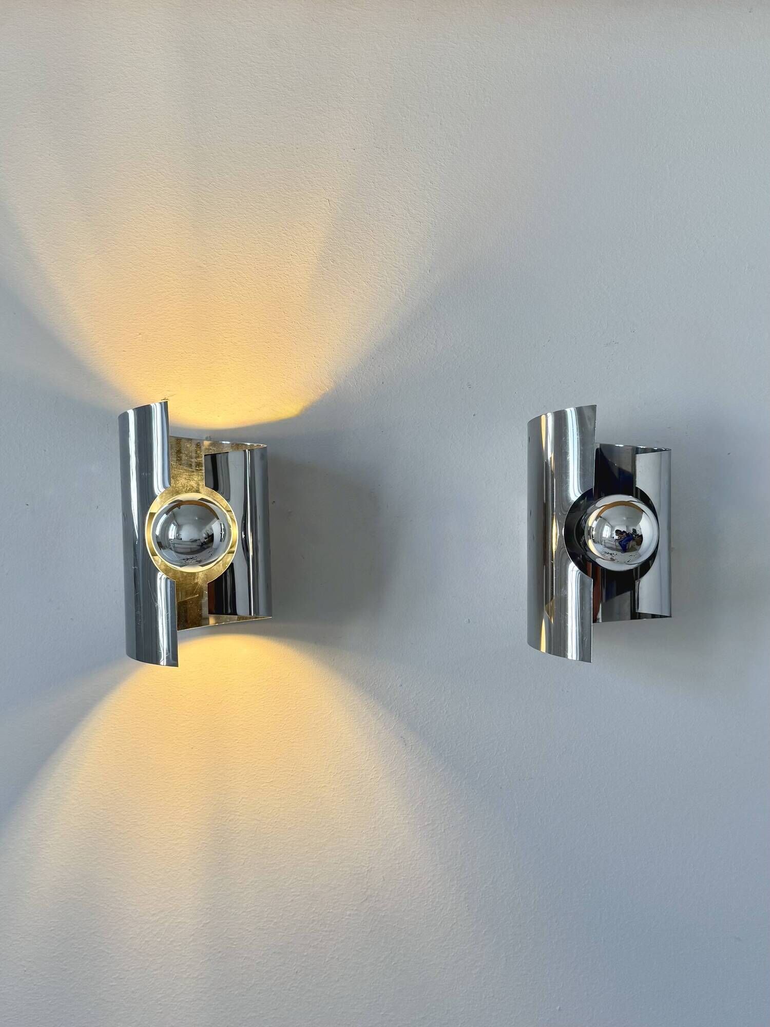 Pair of vintage wall lights, curved chrome metal, France, 1970.