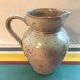 Old gray pitcher with black drawings and vintage stamped handle