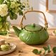 Vintage green teapot with lotus decoration and bamboo handle.