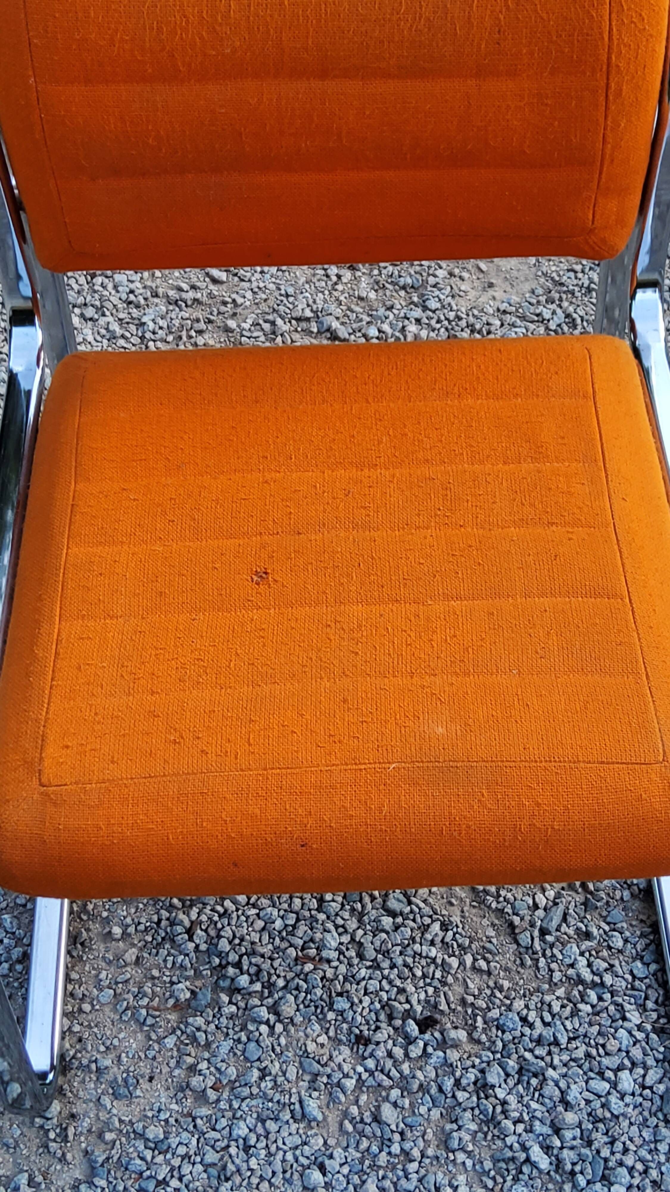 Pair of designer armchairs in orange fabrics and chrome tubes from the 70s