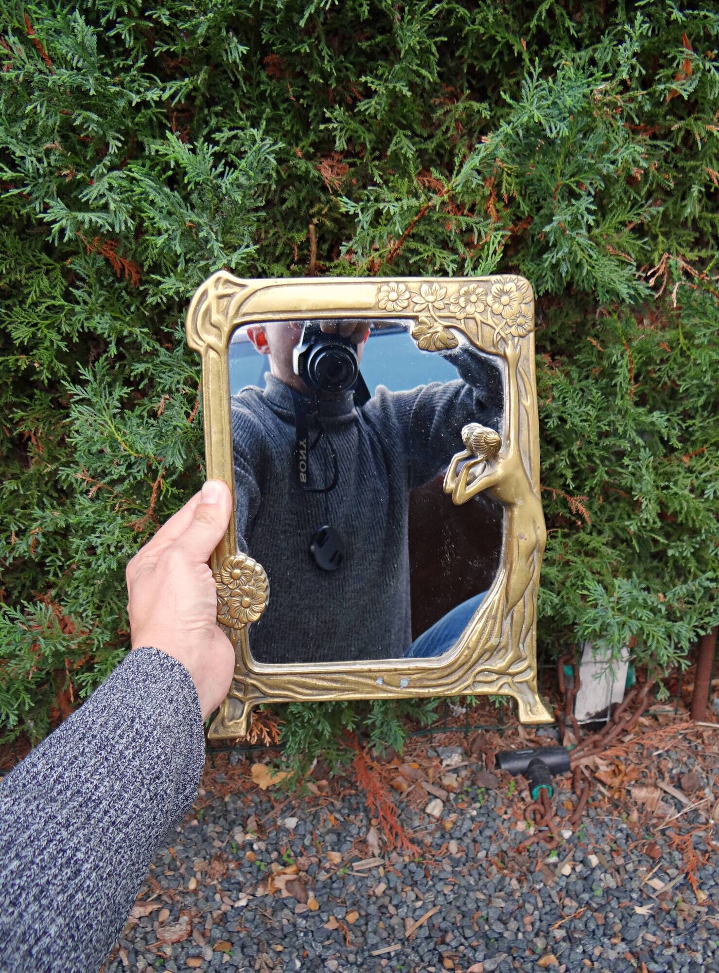 Art Nouveau mirror in gilded brass with a woman figure emerging from a vintage frame