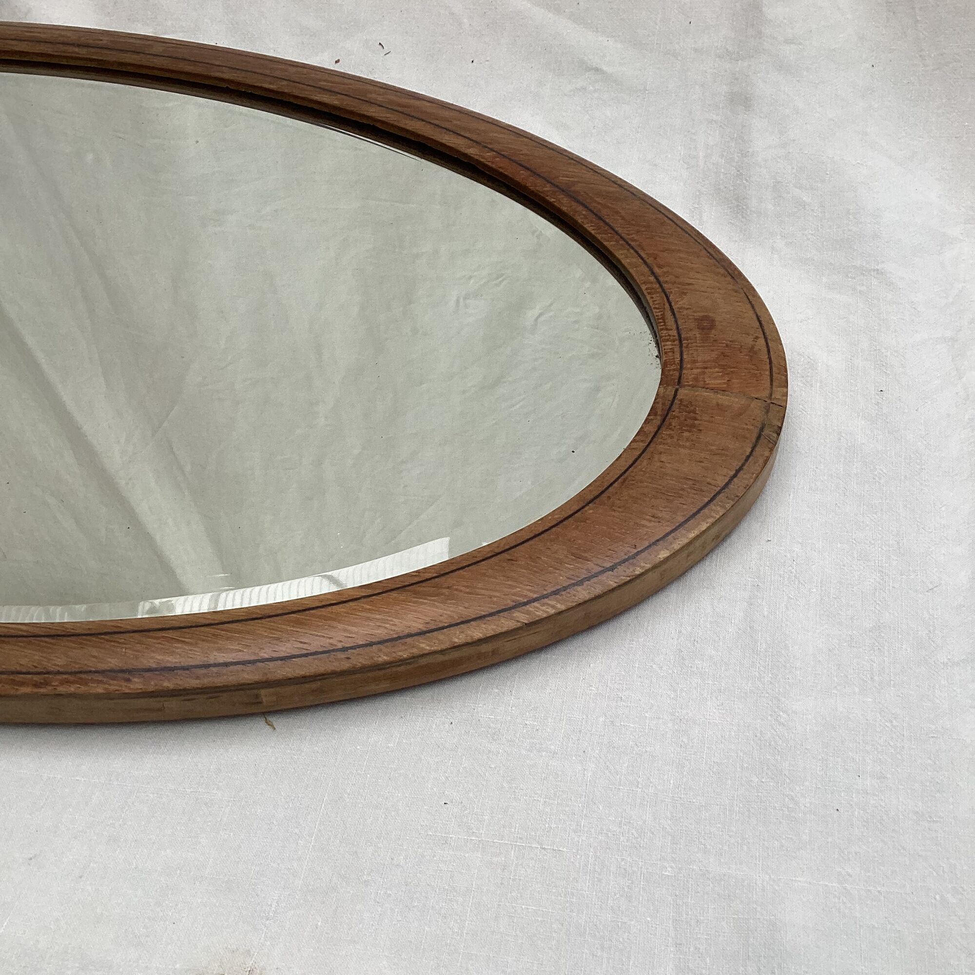 Oval beveled mirror surrounded by light wood dimension: height -74,5cm- width -38,5cm- prof-2cm-