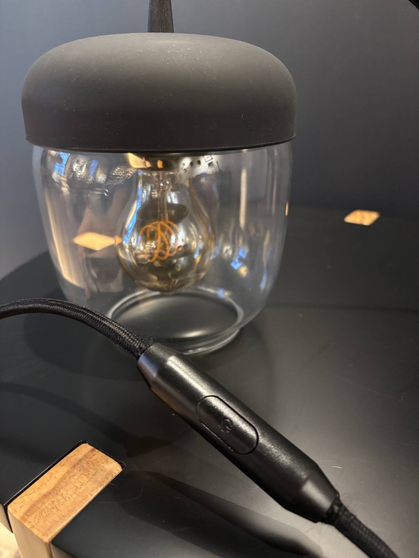 Portable lamp with transparent glass and black plastic.