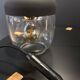 Portable lamp with transparent glass and black plastic.