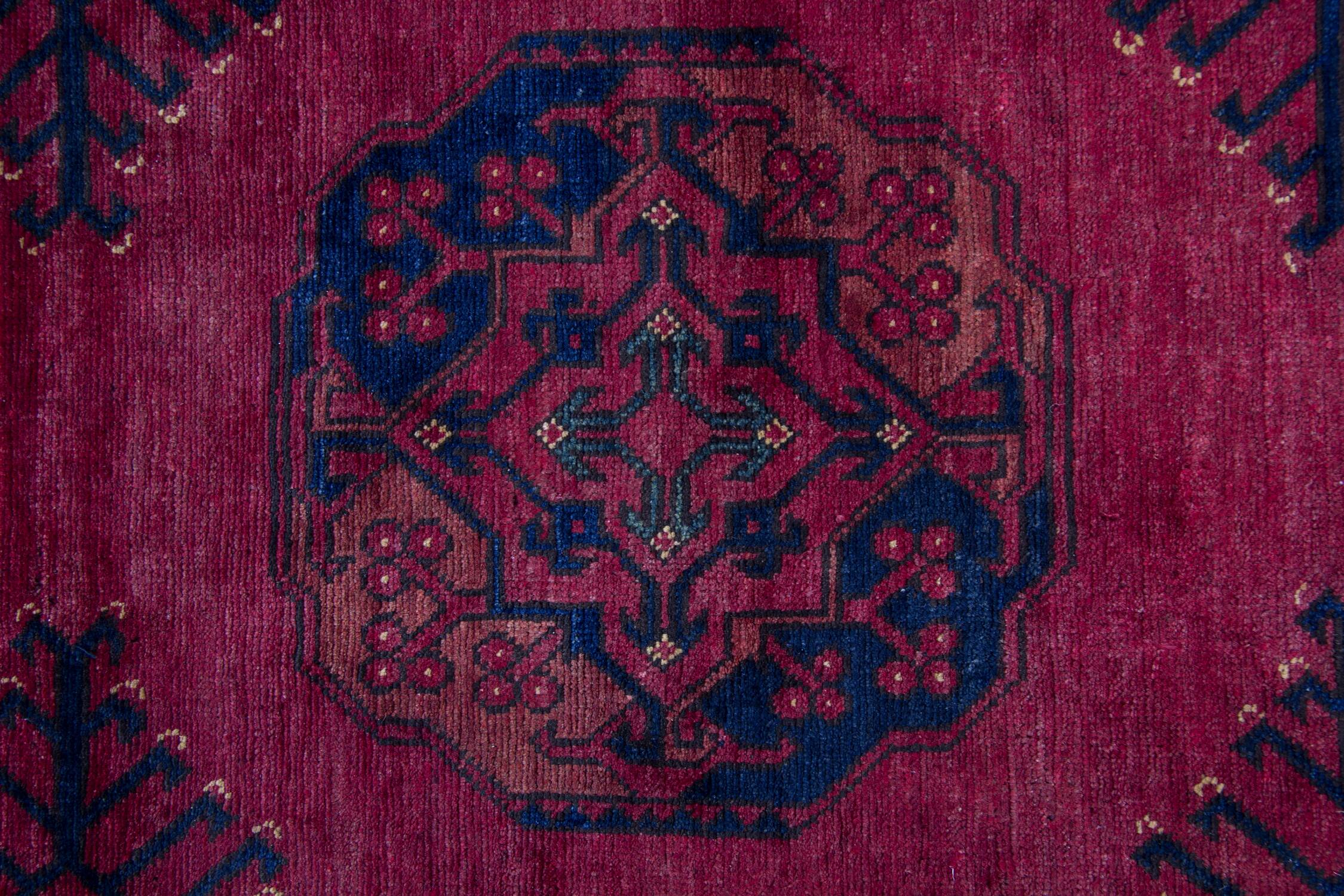 Tapis de couloir en laine à motifs géométriques bordeaux, noué à la main, style tribal afghan.