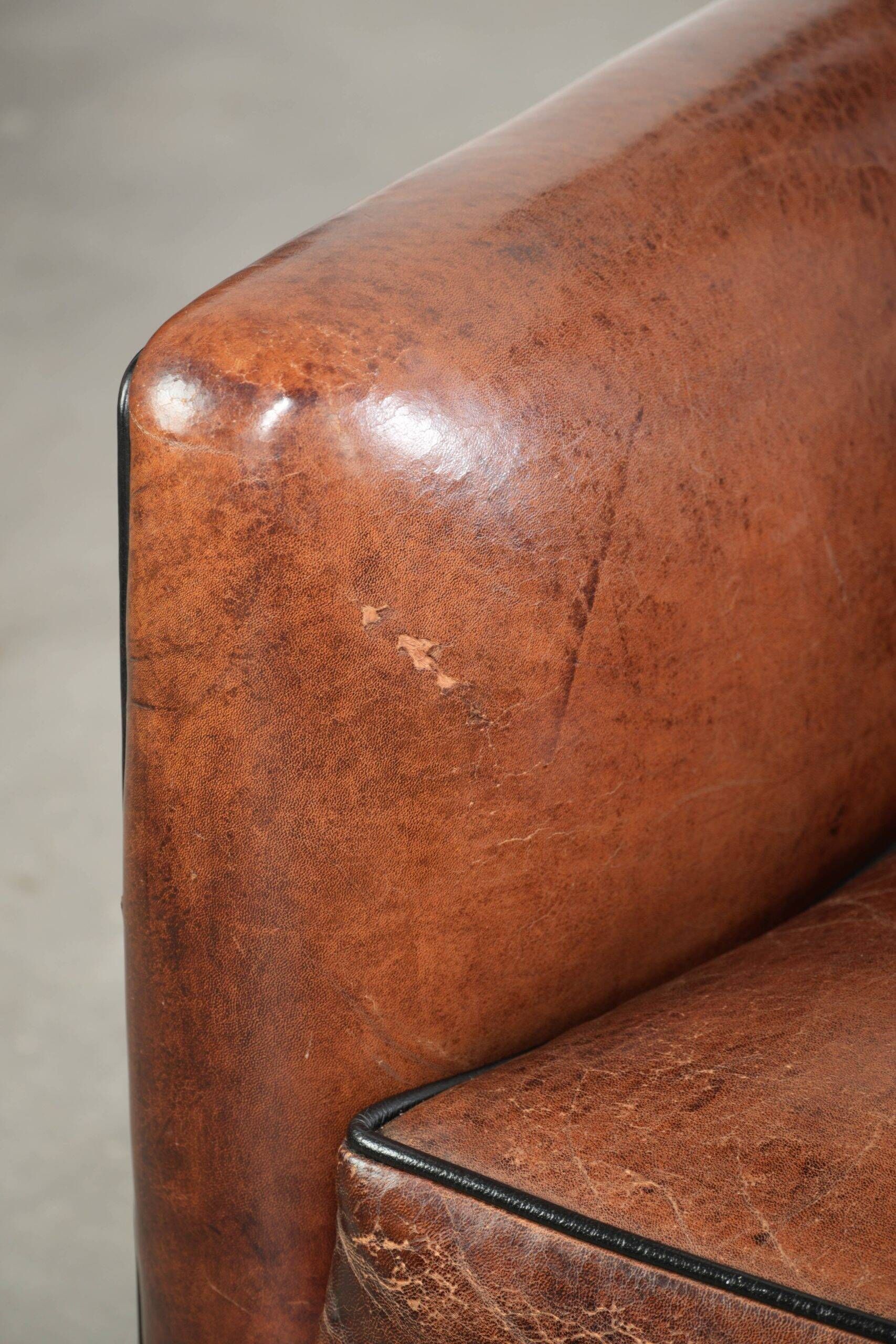 Fauteuil en peau de mouton confortable au design unique, fini avec un passepoil noir.