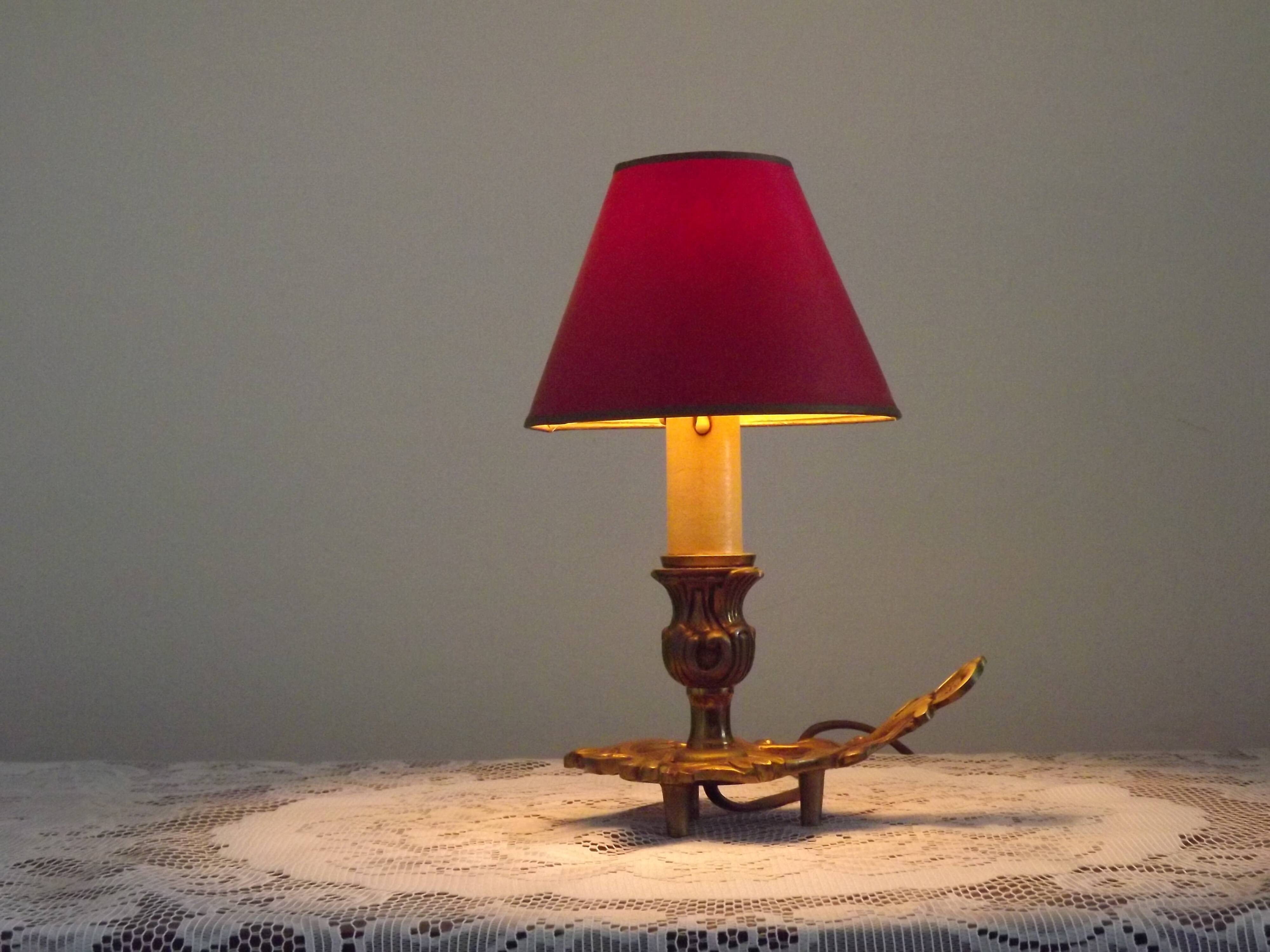 Vintage French bronze Wee Willie Winkie style lamp with red card shade.