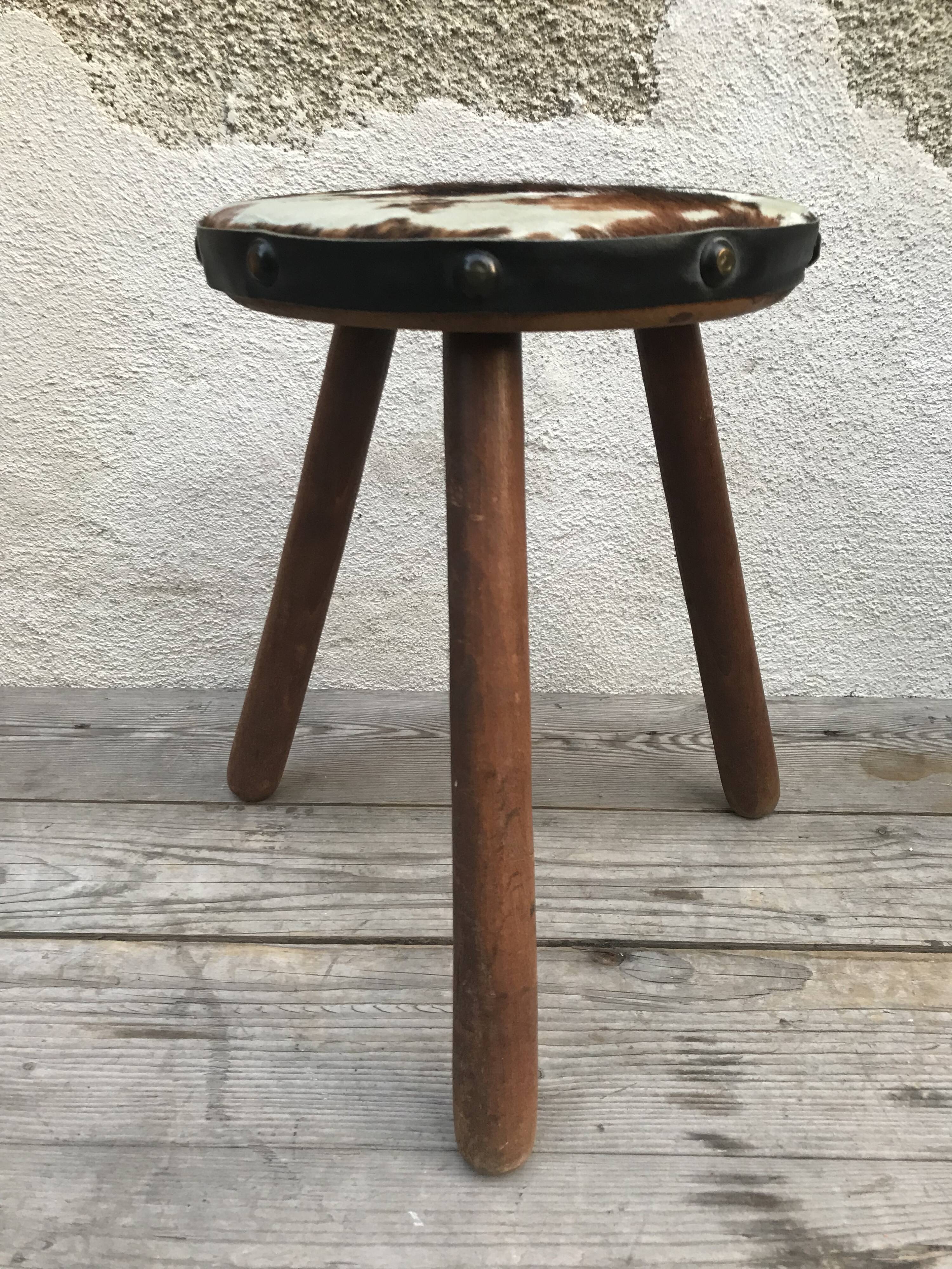 Old wooden tripod stool with seat leather vintage