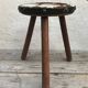 Old wooden tripod stool with seat leather vintage