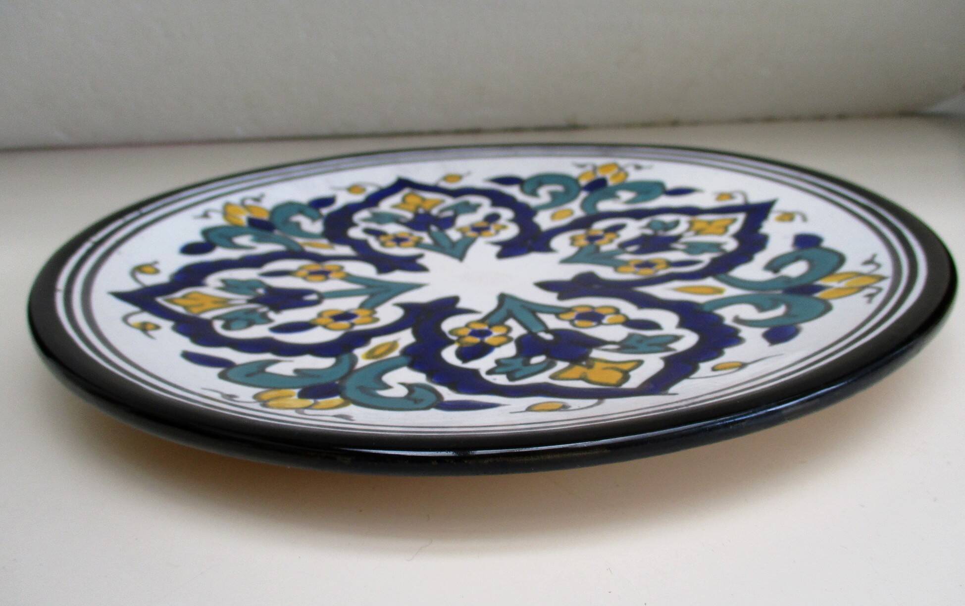 Round ceramic plate with hand-painted decoration