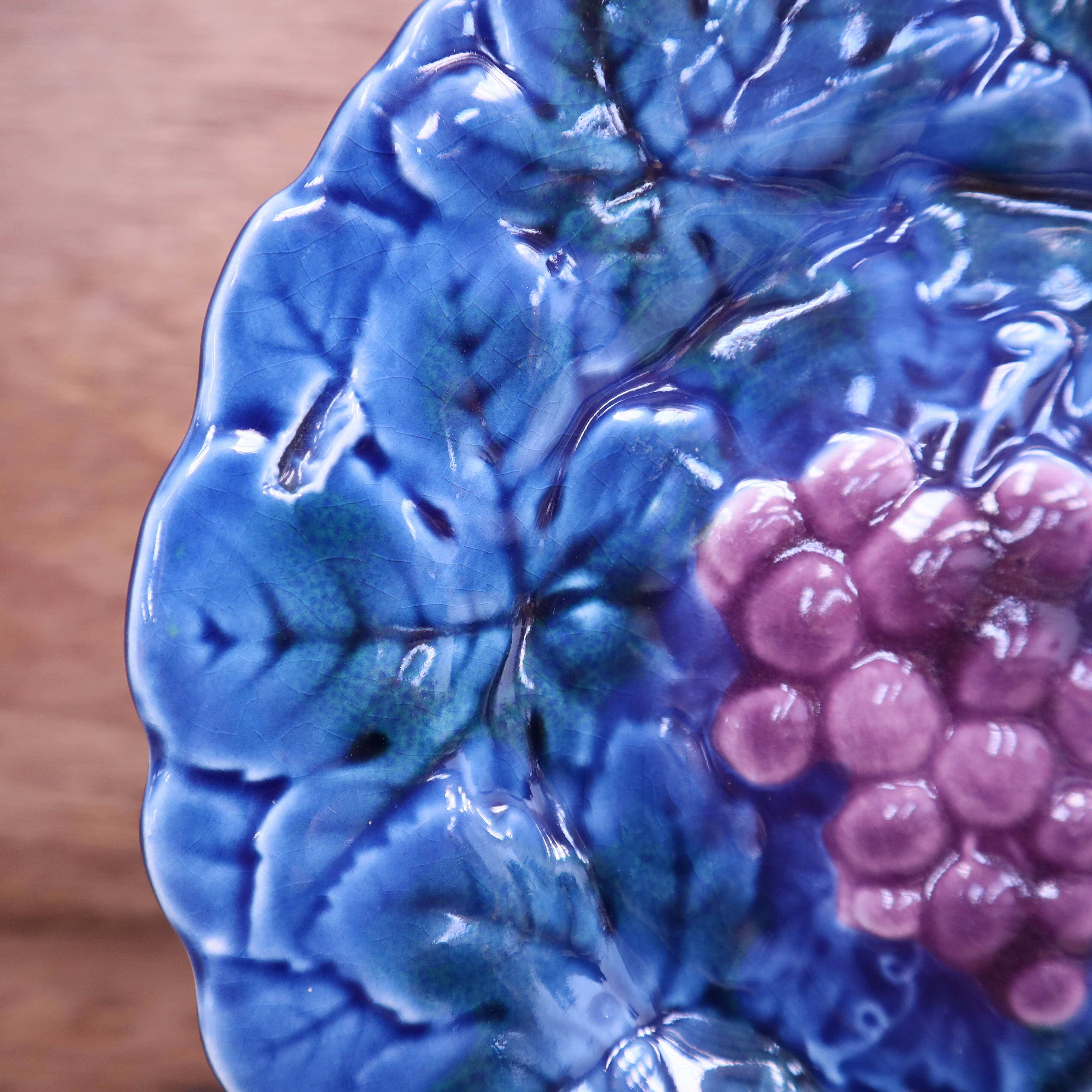 Assiette en barbotine bleue à décor de grappe de raisin Sarreguemines
